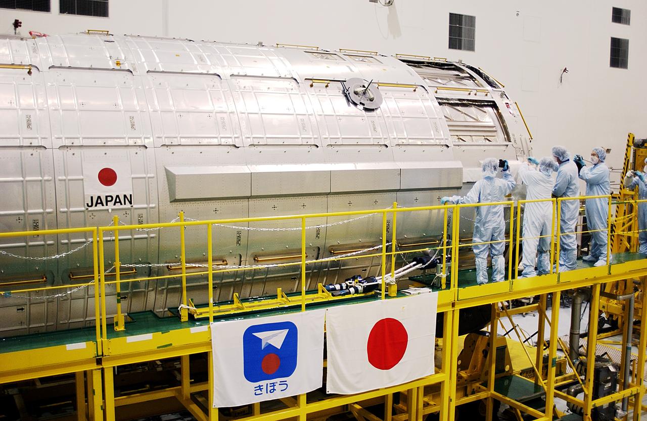 KENNEDY SPACE CENTER, FLA. -  In the Space Station Processing Facility, STS-115 Mission Specialist Joseph Tanner and STS-117 Mission Specialist James Reilly get a close look at the Japanese Experiment Module (JEM).  Reilly and Tanner are at KSC for equipment familiarization, a routine part of astronaut training and launch preparations.