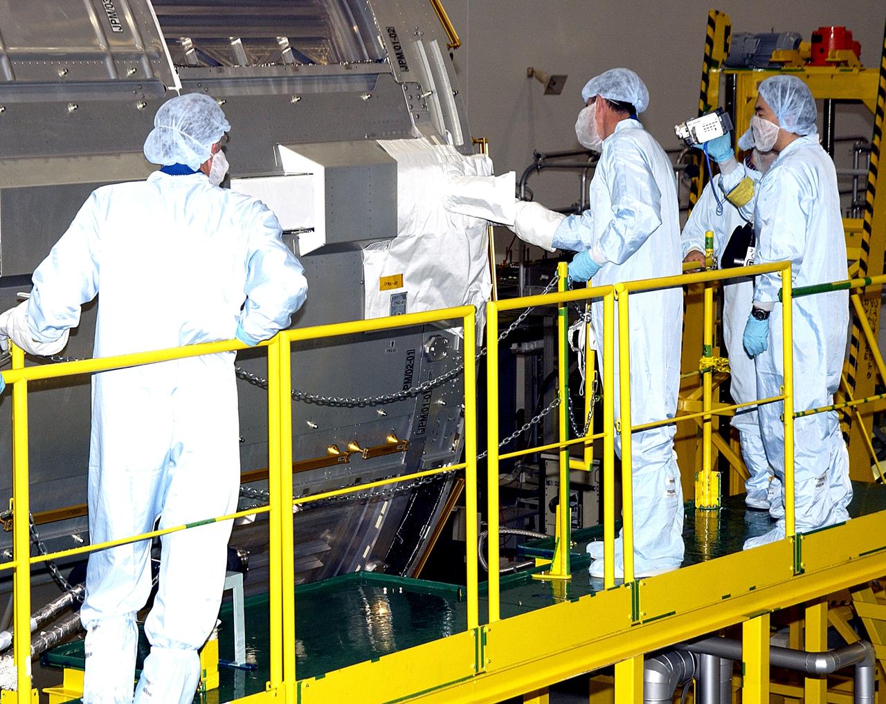 KENNEDY SPACE CENTER, FLA. -  In the Space Station Processing Facility, STS-115 Mission Specialist Joseph Tanner gets hands-on experience with the Japanese Experiment Module (JEM).  Tanner and STS-117 Mission Specialist James Reilly  are at KSC for equipment familiarization, a routine part of astronaut training and launch preparations.