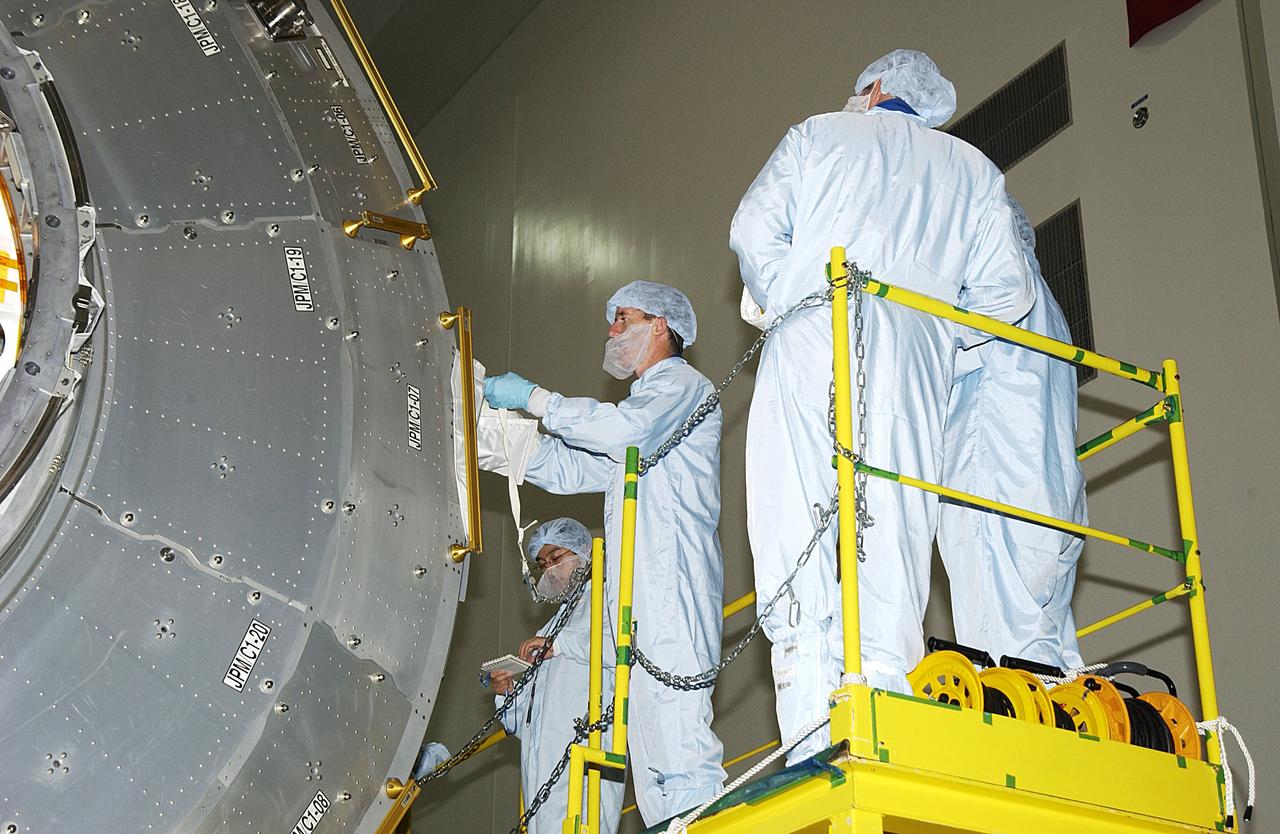 KENNEDY SPACE CENTER, FLA. -  In the Space Station Processing Facility, STS-117 Mission Specialist James Reilly (center) works with the Japanese Experiment Module (JEM).  Reilly and STS-115 Mission Specialist Joseph Tanner are at KSC for equipment familiarization, a routine part of astronaut training and launch preparations.