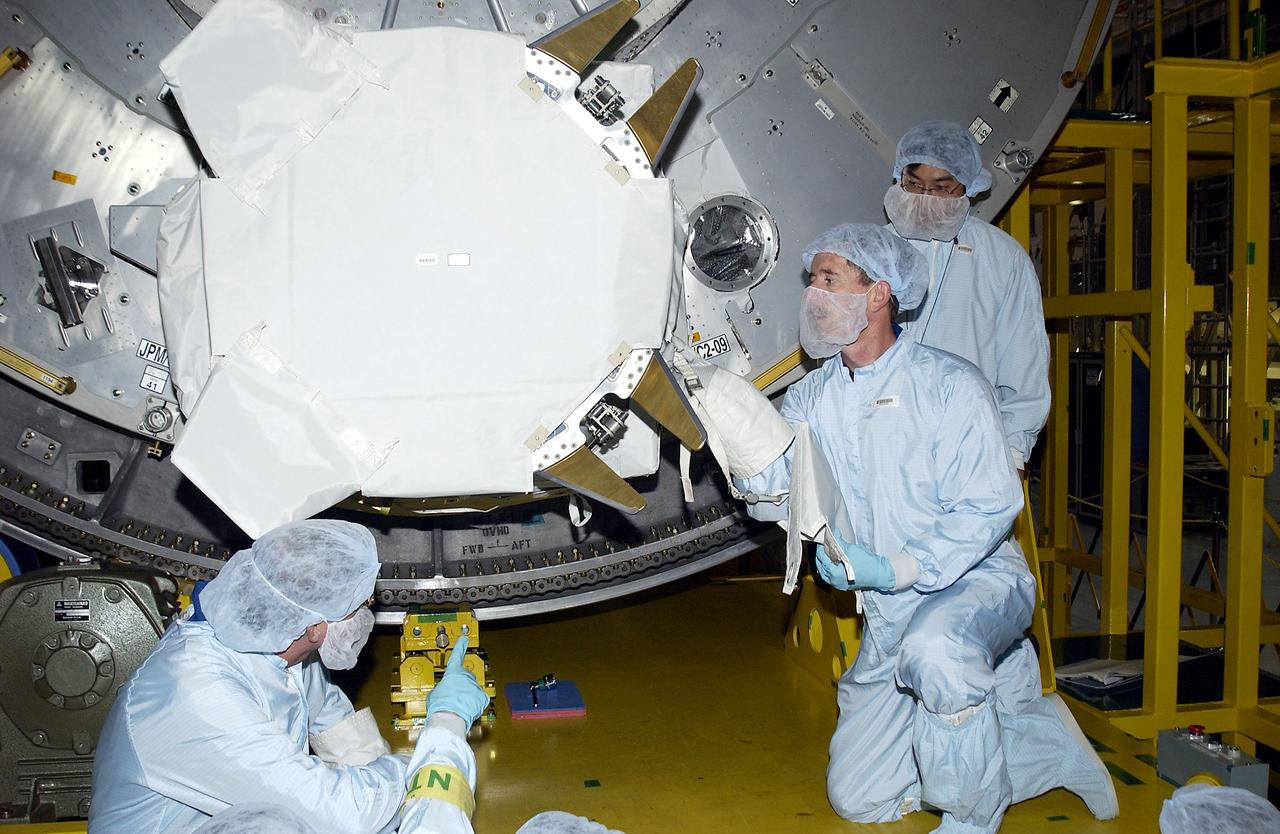KENNEDY SPACE CENTER, FLA. - In the Space Station Processing Facility, STS-117 Mission Specialist James Reilly (right, in front) works with equipment in the Japanese Experiment Module (JEM) as part of training for ExtraVehicular Activity (EVA). At left is STS-115 Mission Specialist Joseph Tanner. Equipment familiarization is a routine part of astronaut training and launch preparations.