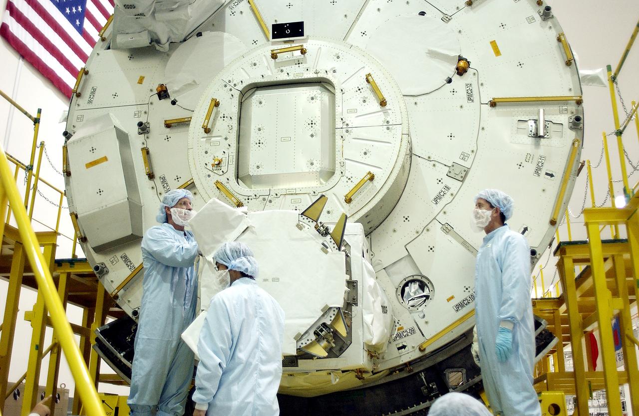 KENNEDY SPACE CENTER, FLA. - In the Space Station Processing Facility, STS-115 Mission Specialist Joseph Tanner (left) and STS-117 Mission Specialist James Reilly (right) look over the Japanese Experiment Module (JEM) behind them. Equipment familiarization is a routine part of astronaut training and launch preparations.