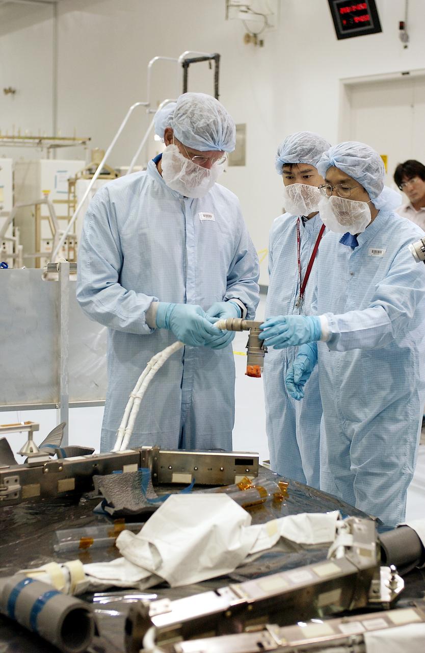 KENNEDY SPACE CENTER, FLA. - In the Space Station Processing Facility, STS-115 Mission Specialist Joseph Tanner (left) checks out a camera and cables to be used in the Japanese Experiment Module (JEM). Known as Kibo, the JEM consists of six components: two research facilities - the Pressurized Module and the Exposed Facility; a Logistics Module attached to each of them; a Remote Manipulator System; and an Inter-Orbit Communication System unit. Kibo also has a scientific airlock through which experiments are transferred and exposed to the external environment of space. The various components of JEM will be assembled in space over the course of three Space Shuttle missions. Equipment familiarization is a routine part of astronaut training and launch preparations.