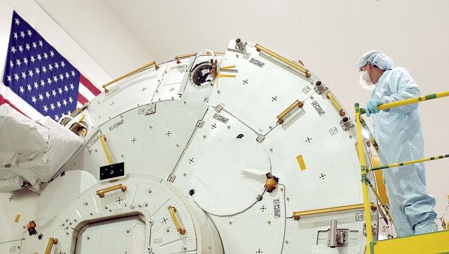 NASA image: KENNEDY SPACE CENTER, FLA. -  In the Space Station Processing Facility, STS-115 Mission Specialist Joseph Tanner takes a closer look at the Japanese Experiment Module (JEM). Known as Kibo, the JEM consists of six components: two research facilities - the Pressurized Module and the Exposed Facility; a Logistics Module attached to each of them; a Remote Manipulator System; and an Inter-Orbit Communication System unit. Kibo also has a scientific airlock through which experiments are transferred and exposed to the external environment of space. The various components of JEM will be assembled in space over the course of three Space Shuttle missions. Equipment familiarization is a routine part of astronaut training and launch preparations.