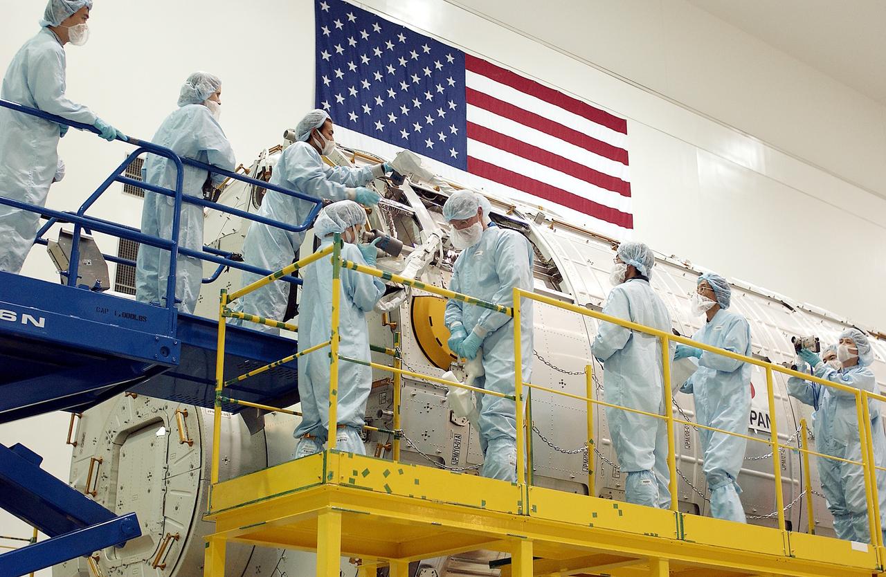 KENNEDY SPACE CENTER, FLA. - In the Space Station Processing Facility, STS-115 Mission Specialist Joseph Tanner (second from left, foreground) works with technicians to learn more about the Japanese Experiment Module (JEM), known as Kibo.  The JEM consists of six components: two research facilities - the Pressurized Module and the Exposed Facility; a Logistics Module attached to each of them; a Remote Manipulator System; and an Inter-Orbit Communication System unit. Kibo also has a scientific airlock through which experiments are transferred and exposed to the external environment of space. The various components of JEM will be assembled in space over the course of three Space Shuttle missions. Equipment familiarization is a routine part of astronaut training and launch preparations.