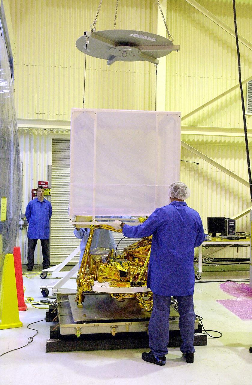 VANDENBERG AIR FORCE BASE, CALIF.- The cover is being lifted off SciSat-1 spacecraft at Vandenberg Air Force Base, Calif.   Sci-Sat, which will undergo instrument checkout and spacecraft functional testing, weighs approximately 330 pounds and after launch will be placed in a 400-mile-high polar orbit to investigate processes that control the distribution of ozone in the upper atmosphere. The data from the satellite will provide Canadian and international scientists with improved measurements relating to global ozone processes and help policymakers assess existing environmental policy and develop protective measures for improving the health of our atmosphere, preventing further ozone depletion. The mission is designed to last two years.