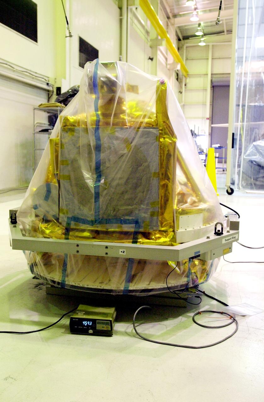 VANDENBERG AIR FORCE BASE, CALIF.-  A covered SciSat-1 spacecraft sits on a test stand at Vandenberg Air Force Base, Calif.  The solar arrays will be attached and the communications systems checked out.   The SciSat-1 weighs approximately 330 pounds and after launch will be placed in a 400-mile-high polar orbit to investigate processes that control the distribution of ozone in the upper atmosphere. The data from the satellite will provide Canadian and international scientists with improved measurements relating to global ozone processes and help policymakers assess existing environmental policy and develop protective measures for improving the health of our atmosphere, preventing further ozone depletion. The mission is designed to last two years.