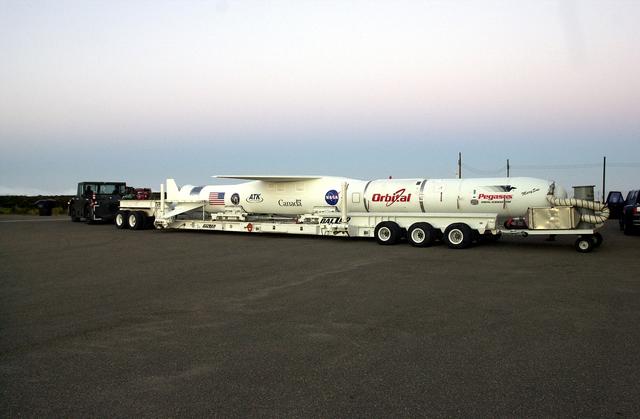 NASA image: VANDENBERG AIR FORCE BASE, CALIF. -  The SciSat-1 payload, with fairing installed and attached to its Pegasus launch vehicle, begins rollout to the hot pad and mating to the L-1011 carrier aircraft.  The SciSat-1 weighs approximately 330 pounds and after launch will be placed in a 400-mile-high polar orbit to investigate processes that control the distribution of ozone in the upper atmosphere. The data from the satellite will provide Canadian and international scientists with improved measurements relating to global ozone processes and help policymakers assess existing environmental policy and develop protective measures for improving the health of our atmosphere, preventing further ozone depletion. The mission is designed to last two years.