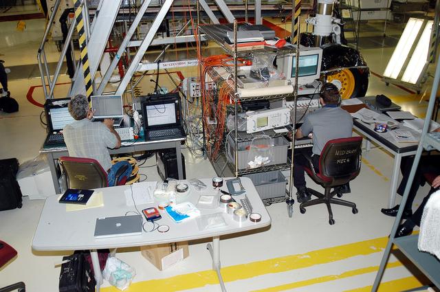 KENNEDY SPACE CENTER, FLA. -  In the Orbiter Processing Facility, Eric Madaras (left), NASA-Langley Research Center, and Jim McGee, The Boeing Company, Huntington Beach, Calif., conduct impulse tests on the right wing leading edge (WLE) of Space Shuttle Endeavour. The tests monitor how sound impulses propagate through the WLE area.  The data collected will be analyzed to explore the possibility of adding new instrumentation to the wing that could automatically detect debris or micrometeroid impacts on the Shuttle while in flight.  The study is part of the initiative ongoing at KSC and around the agency to return the orbiter fleet to flight status.