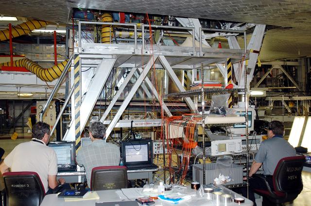 KENNEDY SPACE CENTER, FLA. -  In the Orbiter Processing Facility, Bill Prosser (left) and Eric Madaras, NASA-Langley Research Center, and Jim McGee (right), The Boeing Company, Huntington Beach, Calif., conduct impulse tests on the right wing leading edge (WLE) of Space Shuttle Endeavour. The tests monitor how sound impulses propagate through the WLE area.  The data collected will be analyzed to explore the possibility of adding new instrumentation to the wing that could automatically detect debris or micrometeroid impacts on the Shuttle while in flight.  The study is part of the initiative ongoing at KSC and around the agency to return the orbiter fleet to flight status.