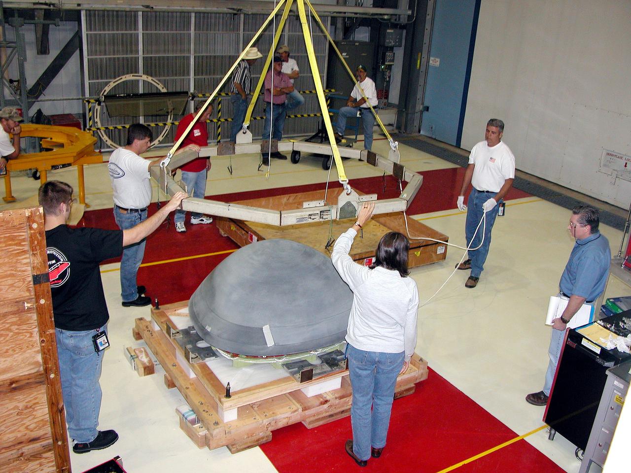 KENNEDY SPACE CENTER, FLA. -  In the Orbiter Processing Facility, workers remove the overhead crane from the nose cap that was removed from Atlantis.   The reinforced carbon-carbon (RCC) nose cap is being sent to the original manufacturing company, Vought in Ft. Worth, Texas, a subsidiary of Lockheed Martin, to undergo non-destructive testing such as CAT scan and thermography.