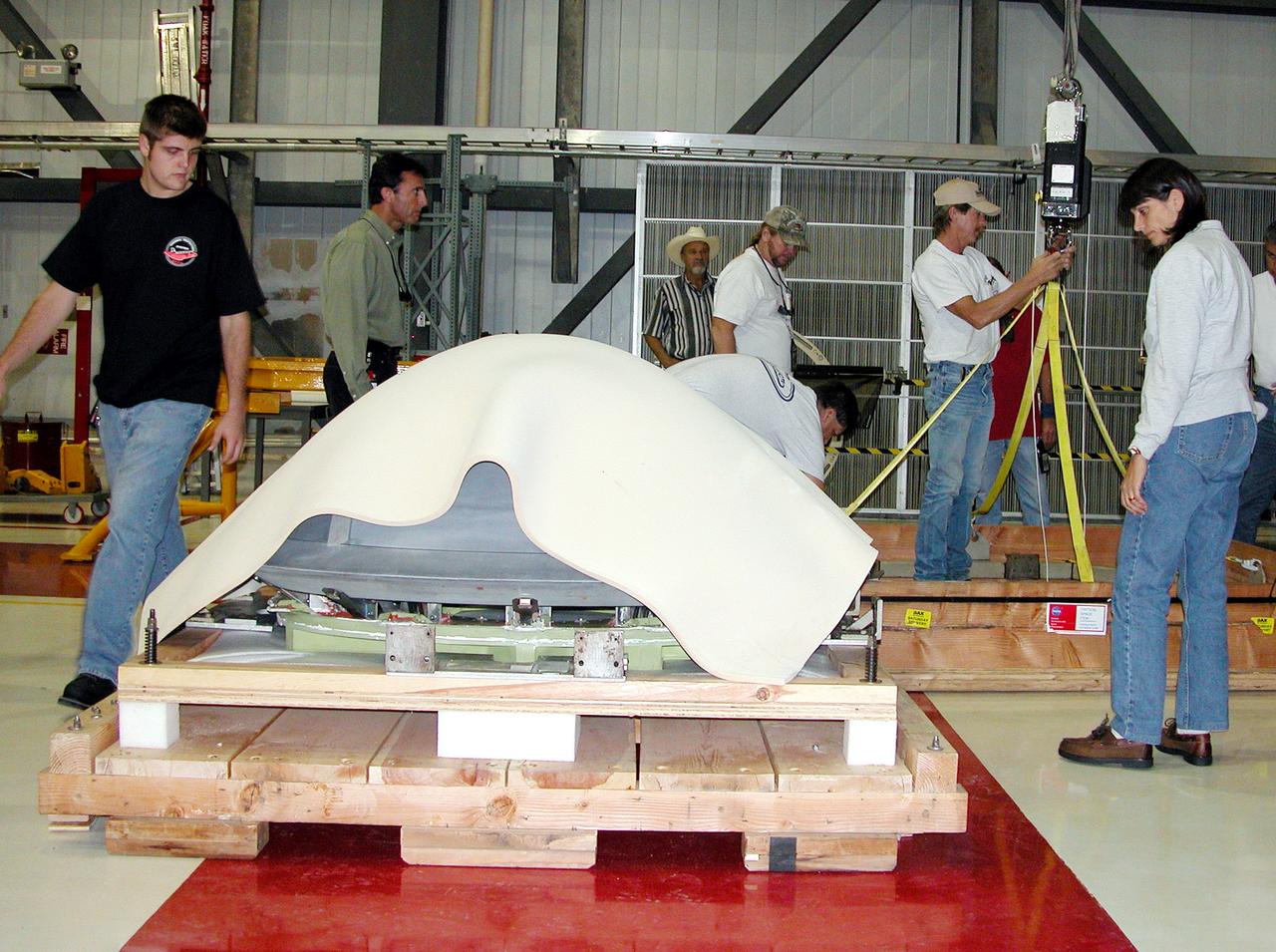 KENNEDY SPACE CENTER, FLA. - In the Orbiter Processing Facility, packing material is placed over the nose cap that was removed from Atlantis. The reinforced carbon-carbon (RCC) nose cap is being sent to the original manufacturing company, Vought in Ft. Worth, Texas, a subsidiary of Lockheed Martin, to undergo non-destructive testing such as CAT scan and thermography.