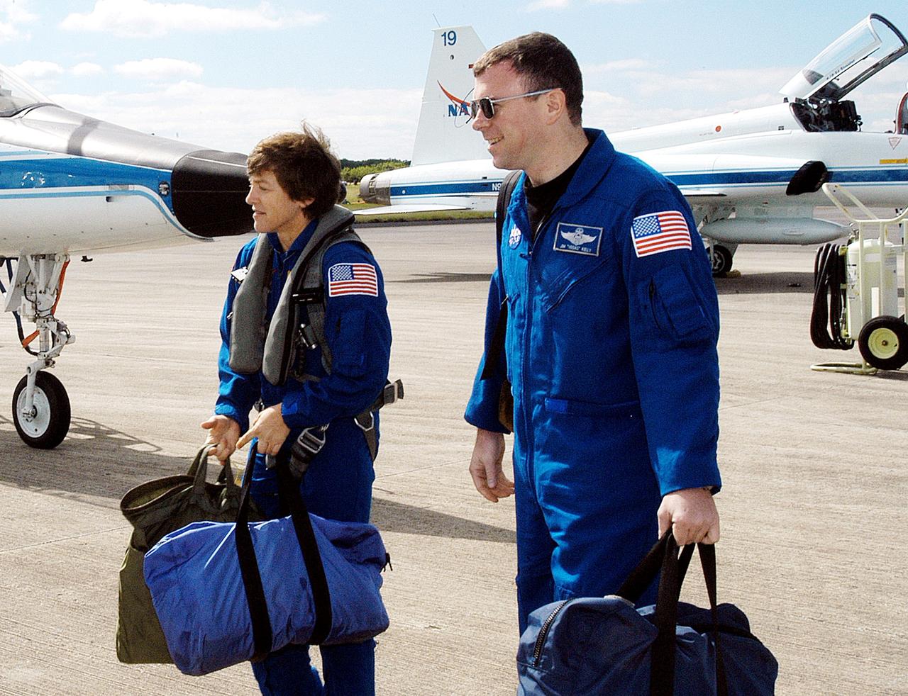 KENNEDY SPACE CENTER, FLA. - Walking away from the T-38 jet aircraft that brought them to KSC are STS-114 Mission Specialist Wendy Lawrence and Pilot James Kelly.  Lawrence is a new addition to the crew.  They and other crew members are at KSC to take part in crew equipment and orbiter familiarization.