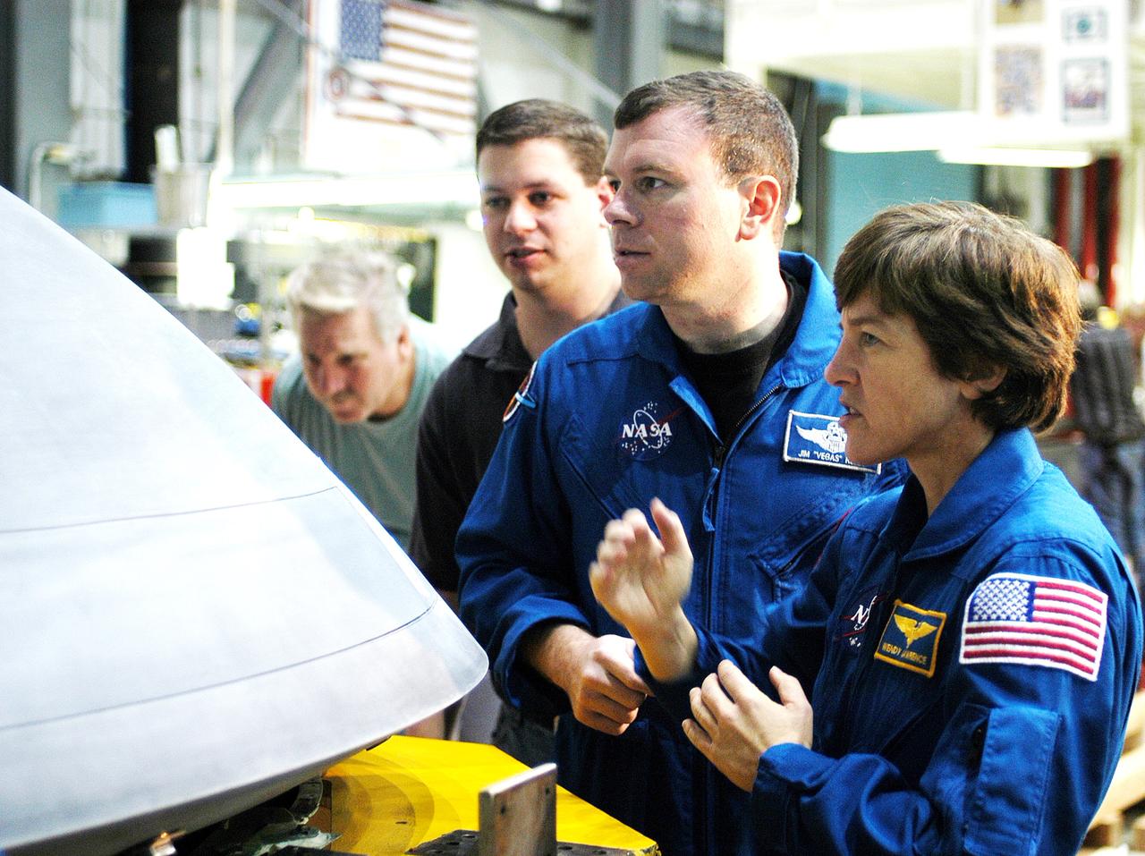 KENNEDY SPACE CENTER, FLA. -  In the Orbiter Processing Facility, STS-114 Pilot James Kelly (center) and Mission Specialist Wendy Lawrence, who was recently added to the mission crew, look at the nose cap recently removed from Atlantis. The STS-114 crew is at KSC to take part in equipment familiarization.