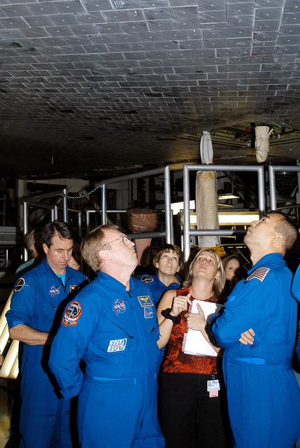 NASA image: KENNEDY SPACE CENTER, FLA. -  In the Orbiter Processing Facility, STS-114 crew members look at the tiles underneath Atlantis.  From left (in flight suits) are Mission Specialists Stephen Robinson and Andy Thomas, Commander Eileen Collins and, at right, Mission Specialist Soichi Noguchi, who is with the Japan Aerospace Exploration Agency, JAXA.  Accompanying them is Glenda Laws, EVA Task Leader, with United Space Alliance at Johnson Space Center.   The STS-114 crew is at KSC to take part in crew equipment and orbiter familiarization.