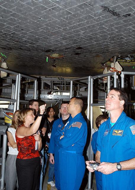 NASA image: KENNEDY SPACE CENTER, FLA. -  In the Orbiter Processing Facility, STS-114 crew members look at the tiles underneath Atlantis.  From center, left to right (in uniform), are Pilot James Kelly, Mission Specialist Soichi Noguchi, Mission Specialists Wendy Lawrence and Stephen Robinson.  Accompanying them at left Glenda Laws, EVA Task Leader, with United Space Alliance at Johnson Space Center. Noguchi is with the Japan Aerospace Exploration Agency, JAXA.  The STS-114 crew is at KSC to take part in crew equipment and orbiter familiarization.