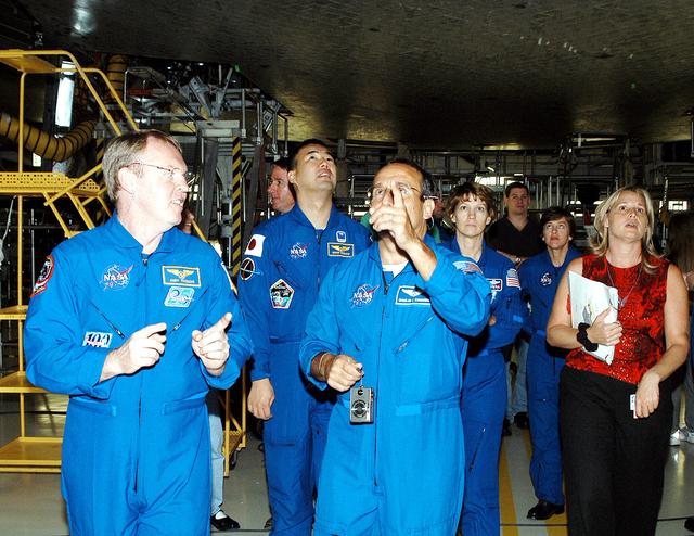 NASA image: KENNEDY SPACE CENTER, FLA. -  The STS-114 mission crew walks through the Orbiter Processing Facility looking at the tiles underneath Atlantis.  From left are Mission Specialists Andy Thomas, Stephen Robinson, Soichi Noguchi and Charles Camarda (pointing); Commander Eileen Collins; and Mission Specialist Wendy Lawrence. At far right Glenda Laws, EVA Task Leader, with United Space Alliance at Johnson Space Center.  Not seen is Pilot James Kelly. Noguchi is with the Japan Aerospace Exploration Agency, JAXA.  The STS-114 crew is at KSC to take part in crew equipment and orbiter familiarization.