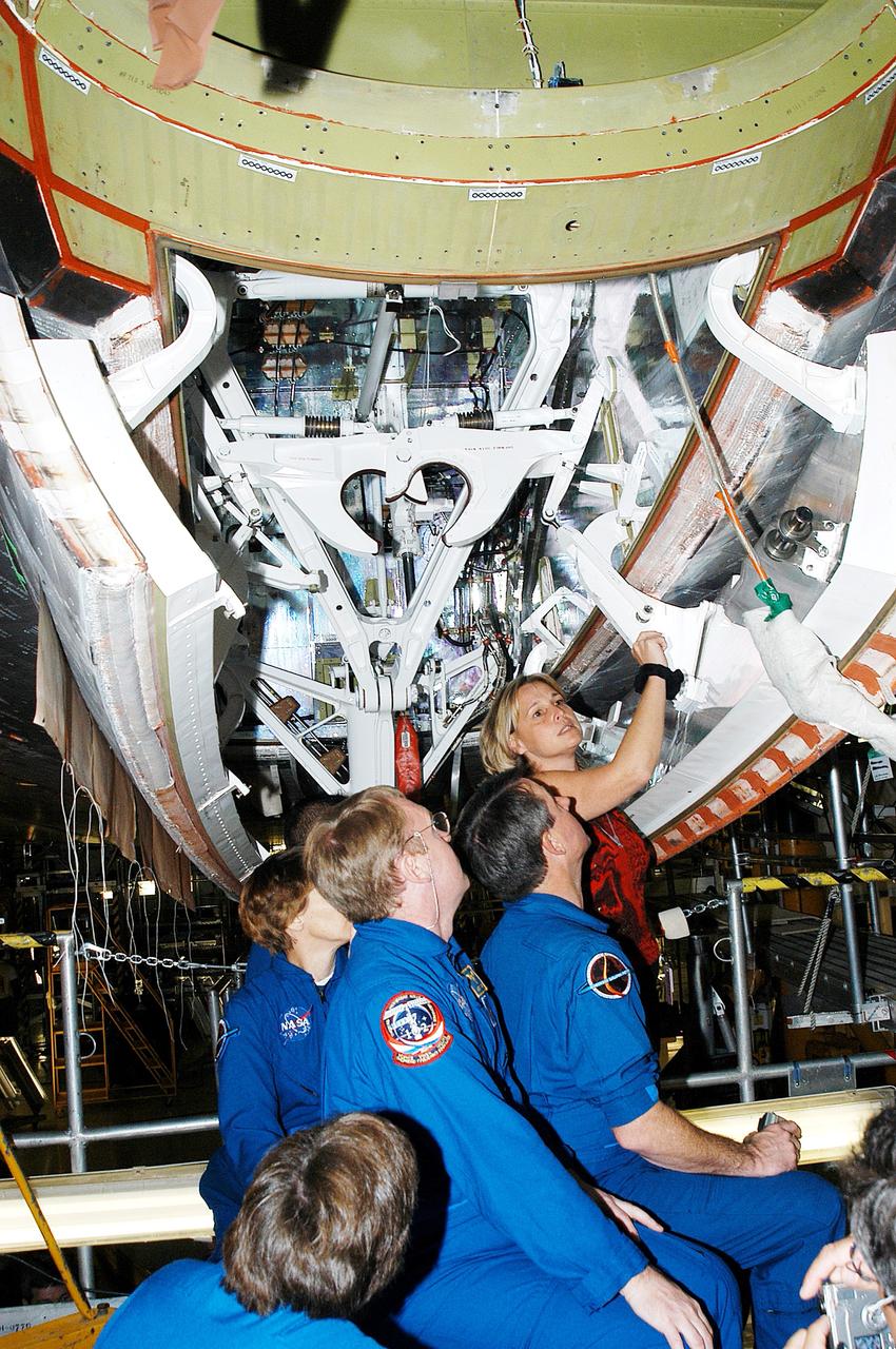 KENNEDY SPACE CENTER, FLA. -  Members of the STS-114 crew look over Shuttle equipment in the Orbiter Processing Facility.  In the foreground is Mission Specialist Wendy Lawrence, who is a new addition to the crew.  Behind her are (left to right) Commander Eileen Collins and Mission Specialists Andy Thomas and Stephen Robinson.  At the rear is Glenda Laws, EVA Task Leader, with United Space Alliance at Johnson Space Center.  The STS-114 crew is at KSC to take part in crew equipment and orbiter familiarization.