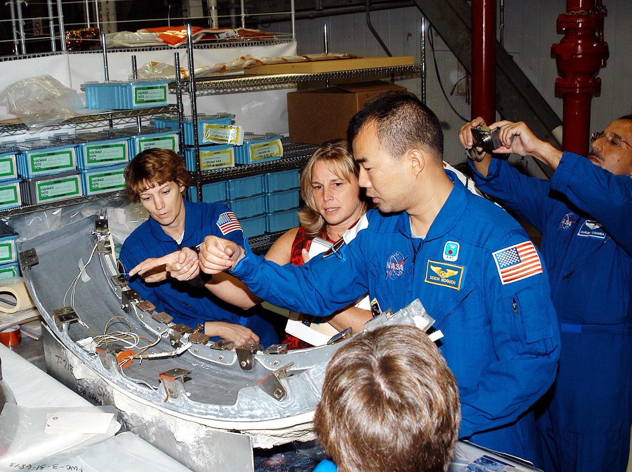 KENNEDY SPACE CENTER, FLA. - Members of the STS-114 crew look over flight  equipment in the Orbiter Processing Facility.  From left are Mission Commander Eileen Collins; Glenda Laws, EVA Task Leader, with United Space Alliance at Johnson Space Center; and Mission Specialists Soichi Noguchi and Charles Camarda.  In the foreground is Mission Specialist Wendy Lawrence.  Noguchi is with the Japan Aerospace Exploration Agency, JAXA. Not seen are Pilot James Kelly and Mission Specialists Andy Thomas and Stephen Robinson.  The STS-114 crew is at KSC to take part in crew equipment and orbiter familiarization.