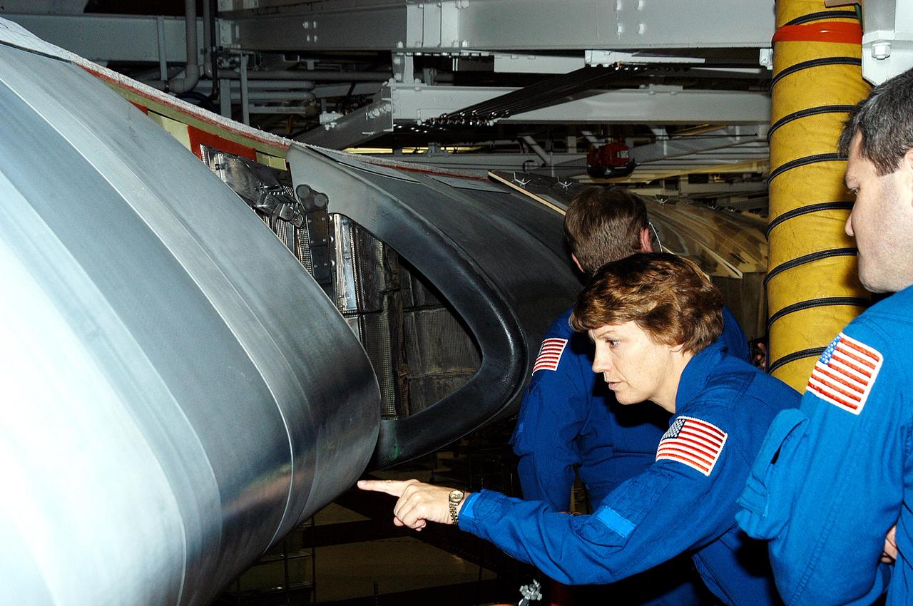 KENNEDY SPACE CENTER, FLA. -  In the Orbiter Processing Facility, STS-114 Mission Commander Eileen Collins looks closely at a reinforced carbon-carbon panel on the wing of Atlantis.  She and other crew members are at KSC to take part in crew equipment and orbiter familiarization.