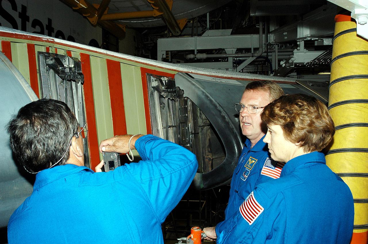 KENNEDY SPACE CENTER, FLA. -   In the Orbiter Processing Facility, STS-114 crew members look at the reinforced carbon-carbon panels on the wing of Atlantis. From left are Mission Specialists Charles Camarda and Andrew Thomas and Commander Eileen Collins.  The STS-114 crew is at KSC to take part in crew equipment and orbiter familiarization.