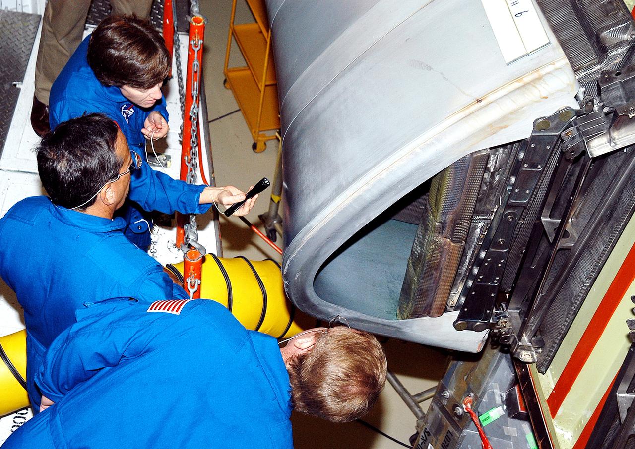 KENNEDY SPACE CENTER, FLA. -    In the Orbiter Processing Facility, STS-114 crew members look at the reinforced carbon-carbon panels on the wing of Atlantis. From top to bottom are Commander Eileen Collins and Mission Specialists Charles Camarda and Andrew Thomas.  The STS-114 crew is at KSC to take part in crew equipment and orbiter familiarization.