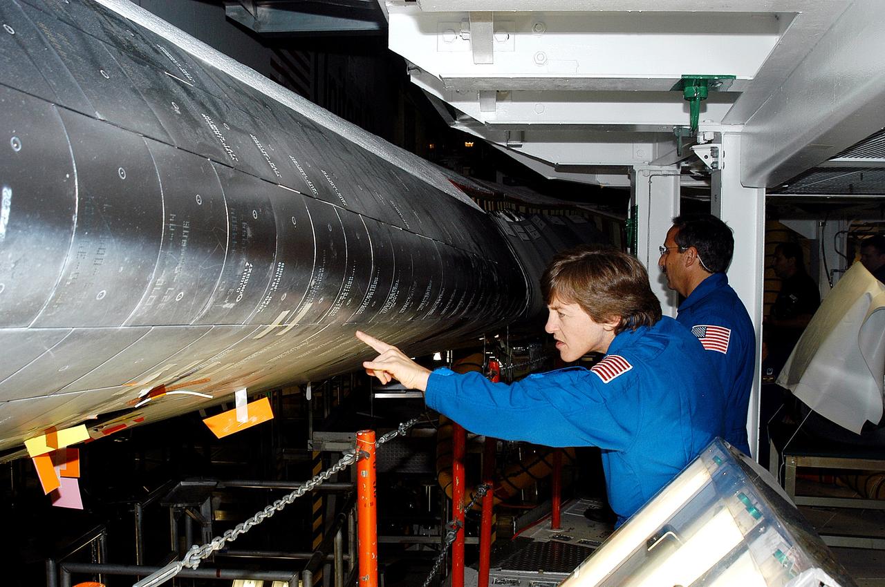KENNEDY SPACE CENTER, FLA. -   In the Orbiter Processing Facility, STS-114 crew members look at the tiles on the wing of Atlantis. In the foreground is Mission Specialist Wendy Lawrence, who is a new addition to the mission crew.  Behind her is Mission Specialist Charles Camarda, also a new addition.  The STS-114 crew is at KSC to take part in crew equipment and orbiter familiarization.