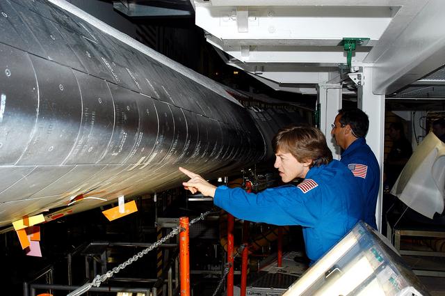 NASA image: KENNEDY SPACE CENTER, FLA. -   In the Orbiter Processing Facility, STS-114 crew members look at the tiles on the wing of Atlantis. In the foreground is Mission Specialist Wendy Lawrence, who is a new addition to the mission crew.  Behind her is Mission Specialist Charles Camarda, also a new addition.  The STS-114 crew is at KSC to take part in crew equipment and orbiter familiarization.