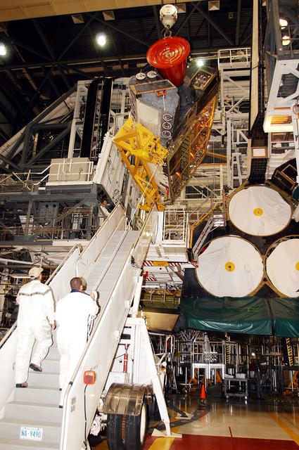 NASA image: KENNEDY SPACE CENTER, FLA. -  In the Orbiter Processing Facility, an orbital maneuvering system (OMS) pod is moved closer to Atlantis for installation.  Two OMS pods are attached to the upper aft fuselage left and right sides. Fabricated primarily of graphite epoxy composite and aluminum, each pod is 21.8 feet long and 11.37 feet wide at its aft end and 8.41 feet wide at its forward end, with a surface area of approximately 435 square feet. Each pod houses the Reaction Control System propulsion components used for inflight maneuvering and is attached to the aft fuselage with 11 bolts.