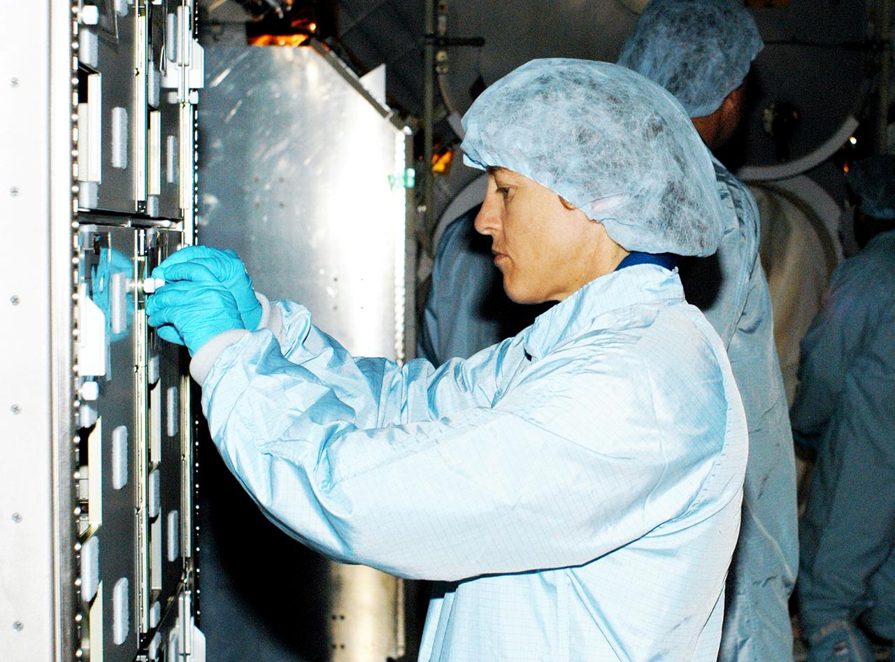 KENNEDY SPACE CENTER, FLA. - In the Space Station Processing Facility, STS-114 Mission Specialist Wendy Lawrence manipulates part of a Multi-Purpose Logistics Module.  Lawrence is a new addition to the mission crew.  The STS-114 crew is at KSC to take part in crew equipment and orbiter familiarization.