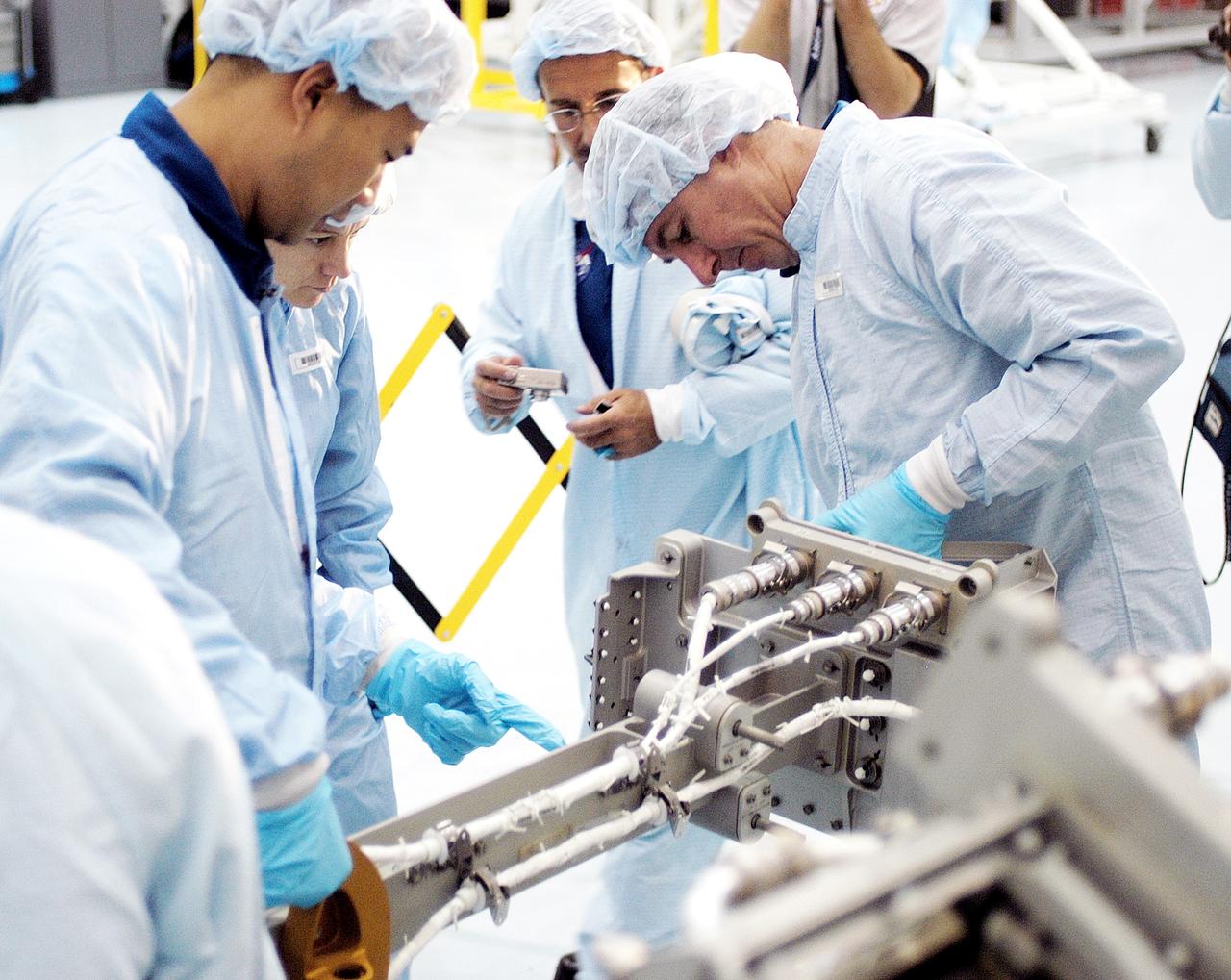 KENNEDY SPACE CENTER, FLA. - In the Space Station Processing Facility, STS-114 crew members get hands-on experience with a Video Stanchion Support Assembly (VSSA).  From left are Mission Specialist Soichi Noguchi, Commander Eileen Collins and Mission Specialists Charles Camarda and Stephen Robinson.  Noguchi is with the Japan Aerospace Exploration Agency, JAXA.  Camarda is a new addition to the mission crew. The STS-114 crew is at KSC to take part in crew equipment and orbiter familiarization.