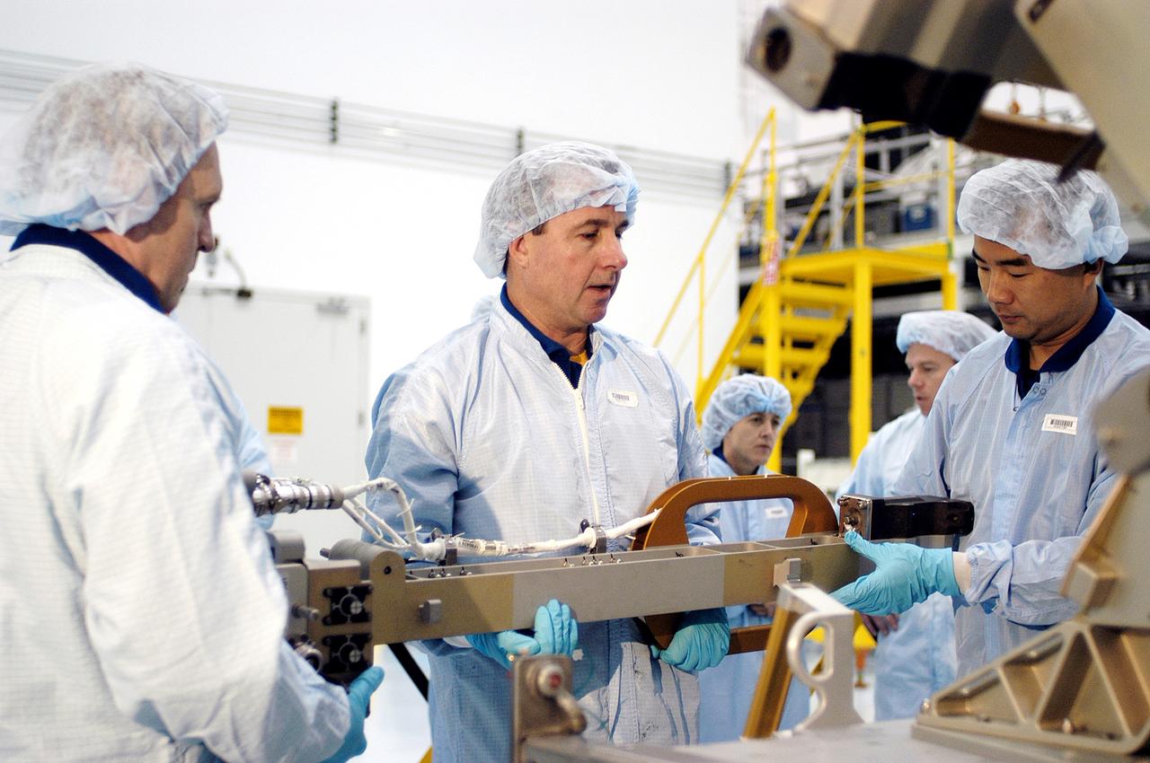 KENNEDY SPACE CENTER, FLA. - In the Space Station Processing Facility, STS-114 crew members get hands-on experience with a Video Stanchion Support Assembly (VSSA).  From left are Mission Specialists Andrew Thomas, Stephen Robinson and Soichi Noguchi, who is with the Japan Aerospace Exploration Agency, JAXA.  Thomas is a new addition to the mission crew. The STS-114 crew is at KSC to take part in crew equipment and orbiter familiarization.