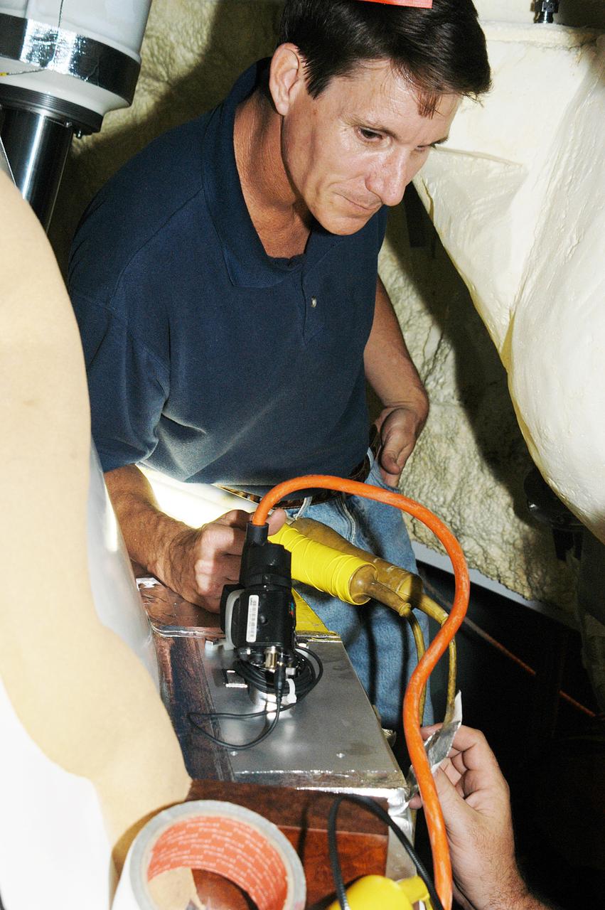 KENNEDY SPACE CENTER, FLA. -  A camera is installed on the aft skirt of a solid rocket booster in preparation for a vibration test of the Mobile Launcher Platform with SRBs and external tank mounted.  The MLP will roll from one bay to another in the Vehicle Assembly Building.