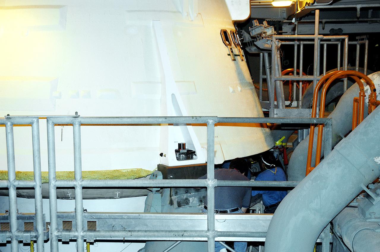 KENNEDY SPACE CENTER, FLA. -  The camera installed on the aft skirt of a solid rocket booster is seen here, framed by the railing.  The installation is in preparation for a vibration test of the Mobile Launcher Platform with SRBs and external tank mounted.  The MLP will roll from one bay to another in the Vehicle Assembly Building.