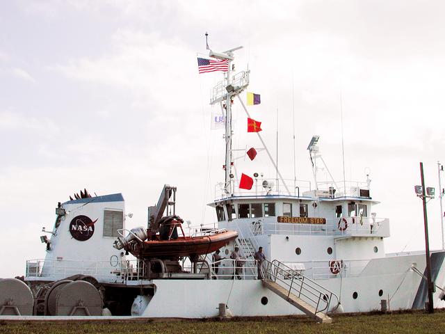 NASA image: KENNEDY SPACE CENTER, FLA. - The Freedom Star is berthed at the Turn Basin near the Vehicle Assembly Building.  The ship has recently returned to KSC after refurbishment at Fort George Island, Fla., including new paint.  Freedom Star is one of the solid rocket booster (SRB) retrieval ships built to recover the SRB casings released over the Atlantic Ocean after launch of a Space Shuttle.  In addition to the SRBs, the ship recovers the drogue and main parachutes that slow the boosters’ speed before splashdown.  Some of the retrieval equipment can be seen on the rear deck.  The ships also tow the external tanks built at the Michoud Space Systems Assembly Facility near New Orleans to Port Canaveral, Fla.  Freedom Star was brought to KSC today for a visit by NATO Parliamentarians.