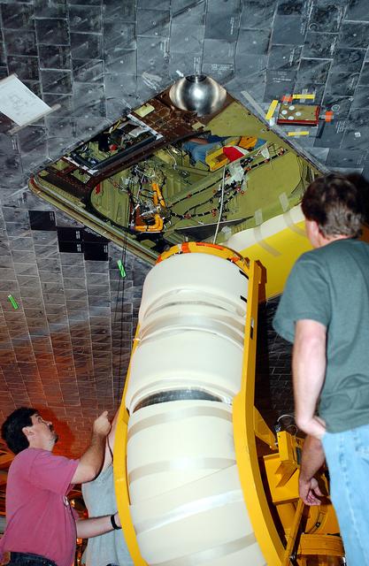 NASA image: KENNEDY SPACE CENTER, FLA. -  In the Orbiter Processing Facility, workers raise the liquid oxygen feedline for the 17-inch disconnect toward orbiter Discovery for installation. The 17-inch liquid oxygen and liquid hydrogen disconnects provide the propellant feed interface from the external tank to the orbiter main propulsion system and the three Shuttle main engines.
