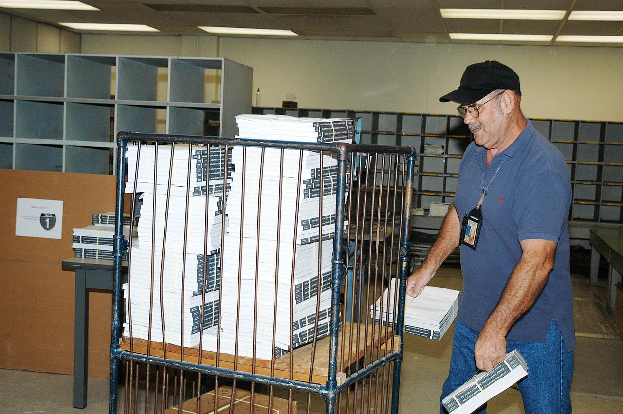 Bill White, in the Mail Room at KSC, stacks copies of the Columbia Accident Investigation Report, which are being distributed to all employees. The delivery is a prelude to NASA Safety and Mission Success Week Nov. 17-21, during which all employees are being encouraged to consider ways they can support and enhance recommendations for improvement stated in the report.