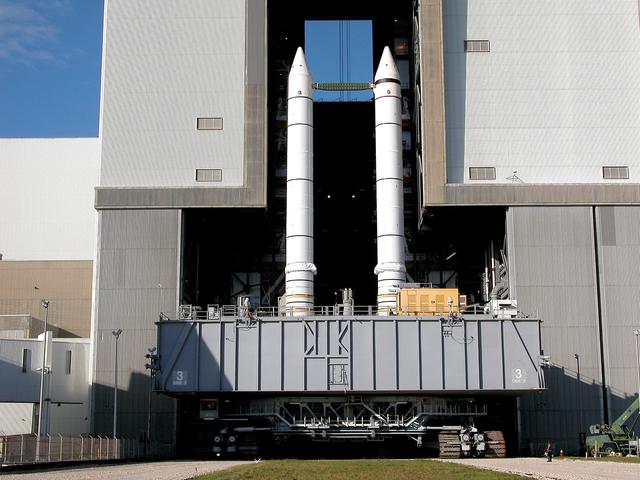 NASA image: KENNEDY SPACE CENTER, FLA. -  As the crawler transporter slowly moves the Mobile Launcher Platform (MLP) out of the Vehicle Assembly Building, the two solid rocket boosters on top are framed in the doorway.  The move is in support of engineering analysis vibration tests on the crawler and MLP. The crawler is moving at various speeds up to 1 mph in an effort to achieve vibration data gathering goals as it leaves the VAB and then returns.  The boosters are braced at the top for stability.  The primary purpose of these rollout tests is to gather data to develop future maintenance requirements on the transport equipment and the flight hardware. Various parts of the MLP and crawler transporter have been instrumented with vibration data collection equipment.