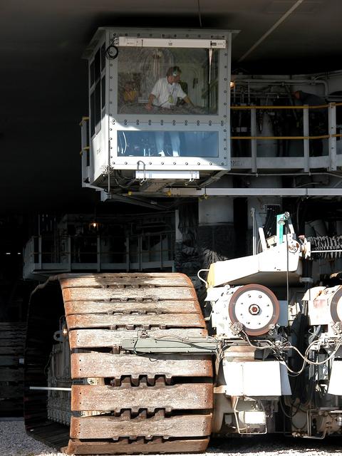 NASA image: KENNEDY SPACE CENTER, FLA. -  As the crawler transporter slowly moves the Mobile Launcher Platform (MLP) out of the Vehicle Assembly Building, the driver of the front control cab can be seen.  The MLP is carrying two solid rocket boosters for engineering analysis vibration tests on the crawler and MLP.    The crawler is moving at various speeds up to 1 mph in an effort to achieve vibration data gathering goals as it leaves the VAB and then returns.  The boosters are braced at the top for stability.  The primary purpose of these rollout tests is to gather data to develop future maintenance requirements on the transport equipment and the flight hardware. Various parts of the MLP and crawler transporter have been instrumented with vibration data collection equipment.