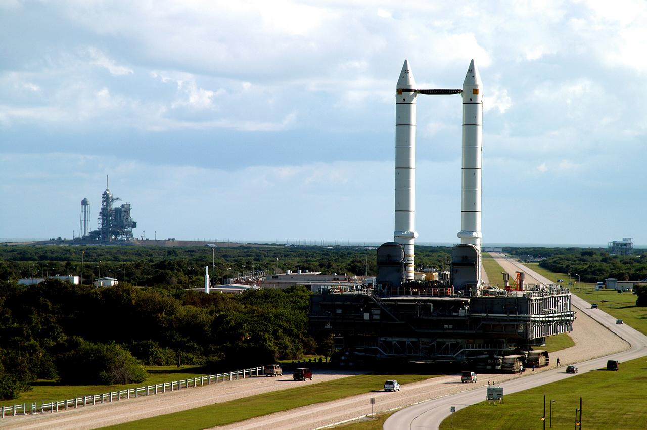 KENNEDY SPACE CENTER, FLA. -  The crawler transporter slowly moves the Mobile Launcher Platform (MLP), carrying a set of twin solid rocket boosters, along the crawlerway in support of engineering analysis vibration tests on the crawler and MLP.   In the distance, at left, is Launch Pad 39A. The crawler is moving at various speeds up to 1 mph in an effort to achieve vibration data gathering goals as it leaves the VAB and then returns.  The boosters are braced at the top for stability.  The primary purpose of these rollout tests is to gather data to develop future maintenance requirements on the transport equipment and the flight hardware. Various parts of the MLP and crawler transporter have been instrumented with vibration data collection equipment.