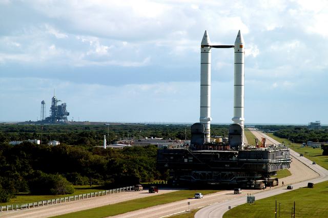 NASA image: KENNEDY SPACE CENTER, FLA. -  The crawler transporter slowly moves the Mobile Launcher Platform (MLP), carrying a set of twin solid rocket boosters, along the crawlerway in support of engineering analysis vibration tests on the crawler and MLP.   In the distance, at left, is Launch Pad 39A. The crawler is moving at various speeds up to 1 mph in an effort to achieve vibration data gathering goals as it leaves the VAB and then returns.  The boosters are braced at the top for stability.  The primary purpose of these rollout tests is to gather data to develop future maintenance requirements on the transport equipment and the flight hardware. Various parts of the MLP and crawler transporter have been instrumented with vibration data collection equipment.
