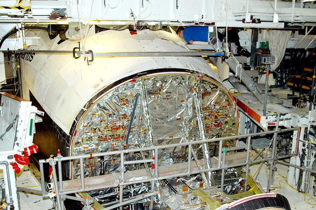 NASA image: KENNEDY SPACE CENTER, FLA. -  In the Orbiter Processing Facility, United Space Alliance technician Jamie Haynes checks the tiles on the nose of orbiter Atlantis as part of return-to-flight activities.  Atlantis is scheduled for mission STS-114, a return-to-flight test mission to the International Space Station.