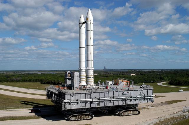 NASA image: KENNEDY SPACE CENTER, FLA. -  Mobile Launcher Platform (MLP) number 3 and a set of twin solid rocket boosters, atop the crawler-transporter, inch along the crawlerway in support of the second engineering analysis vibration test on the crawler and MLP. The crawler is moving at various speeds up to 1 mph in an effort to achieve vibration data gathering goals as it leaves the VAB, travels toward Launch Pad 39A (on the horizon) and then returns.  The boosters are braced at the top for stability.  The primary purpose of these rollout tests is to gather data to develop future maintenance requirements on the transport equipment and the flight hardware. Various parts of the MLP and crawler transporter have been instrumented with vibration data collection equipment.