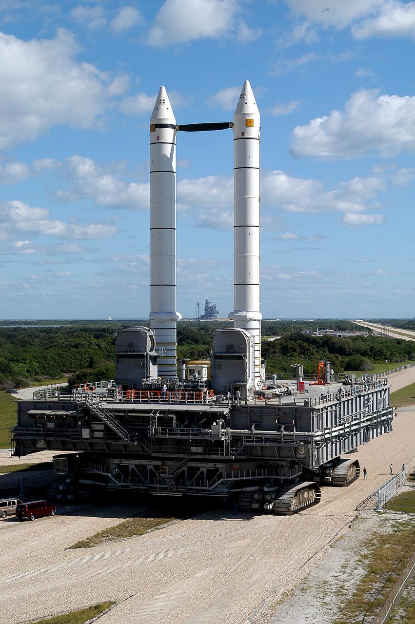 KENNEDY SPACE CENTER, FLA. -  Mobile Launcher Platform (MLP) number 3 and a set of twin solid rocket boosters, atop the crawler-transporter, inch along the crawlerway in support of the second engineering analysis vibration test on the crawler and MLP. The crawler is moving at various speeds up to 1 mph in an effort to achieve vibration data gathering goals as it leaves the VAB, travels toward Launch Pad 39A (framed between the boosters), and then returns.  The boosters are braced at the top for stability.  The primary purpose of these rollout tests is to gather data to develop future maintenance requirements on the transport equipment and the flight hardware. Various parts of the MLP and crawler transporter have been instrumented with vibration data collection equipment.
