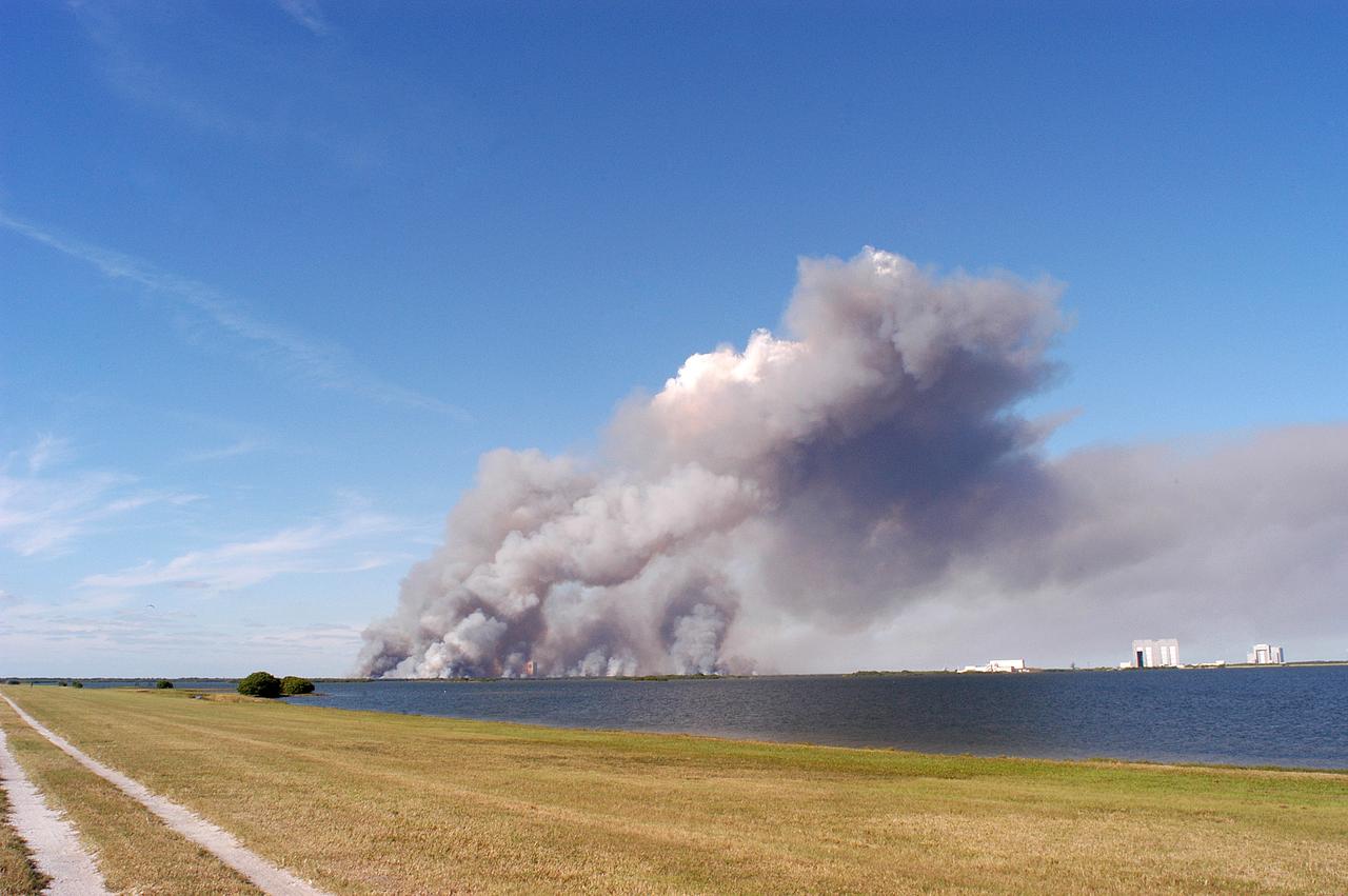 KENNEDY SPACE CENTER, FLA. - A successful controlled burn near KSC’s Launch Complex 39 area creates clouds of smoke in a clear blue sky. The water seen is the Banana River.