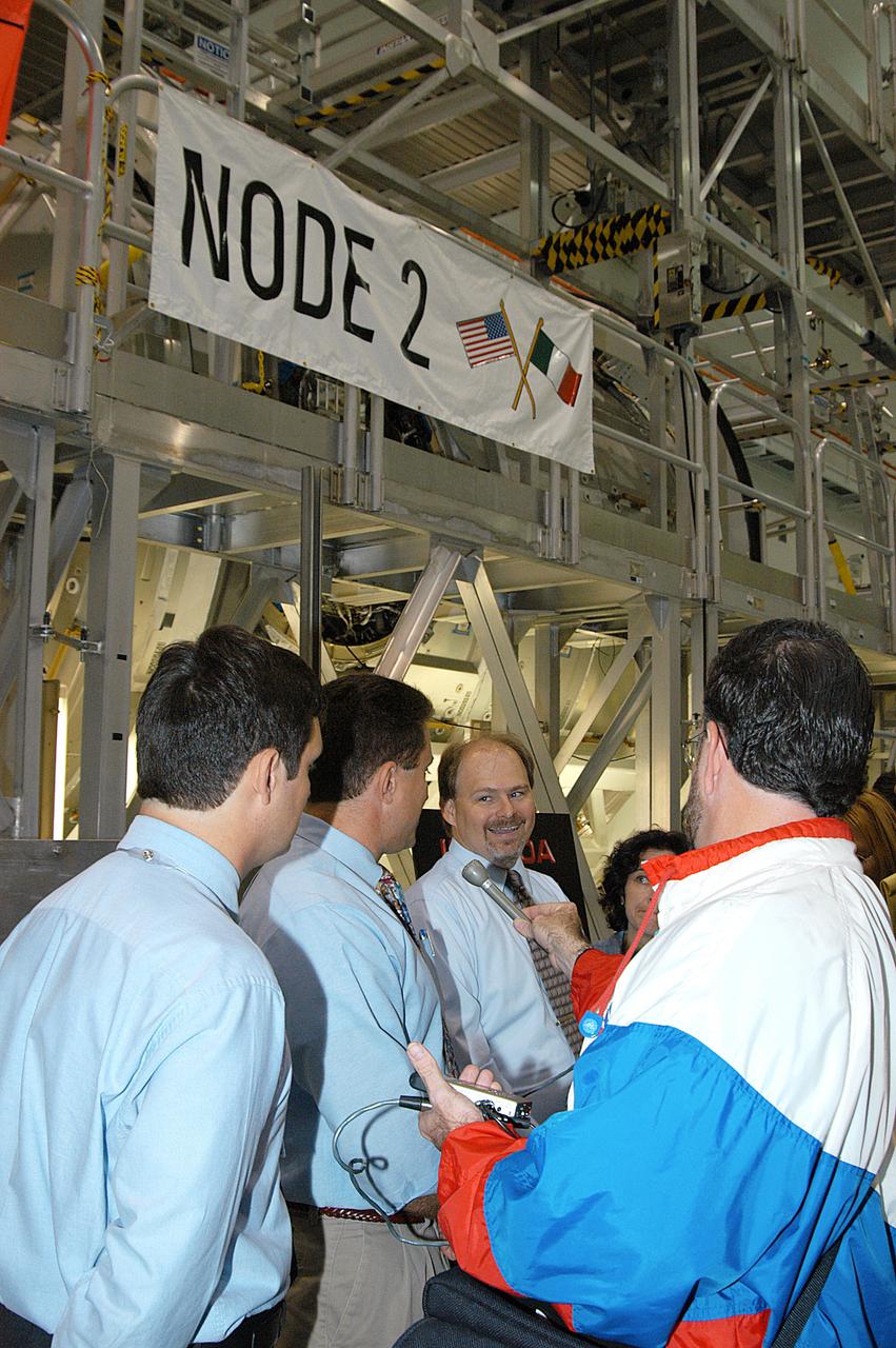 In the Space Station Processing Facility (SSPF), Richard Kuhns, NASA Node 2/10A Mission Integration Engineer, International Space Station and Payload Processing, discusses the Node 2 with members of the media. From left are Stefano Masiello, Alenia Spazio; Steve Shannon, Node 2 Mission Manager, The Boeing Co.; and Kuhns. The installation of NASA's Node 2 denotes the U.S. Core Complete stage of International Space Station assembly and, among other functions, will provide a passageway between four Station science experiment facilities: the U.S. Destiny Laboratory, the Kibo Japanese Experiment Module, the European Columbus Laboratory and the Centrifuge Accommodation Module. Reporters were invited to commemorate the fifth anniversary of the launch of the first element of the Station with a tour of the SSPF and had the opportunity to see Space Station hardware that is being processed for deployment once the Space Shuttles return to flight. NASA and Boeing mission managers were on hand to talk about the various hardware elements currently being processed for flight.