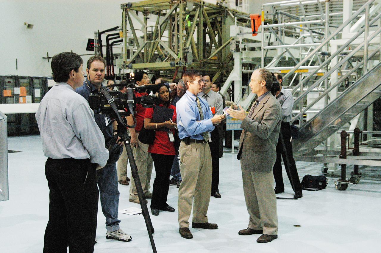 In the Space Station Processing Facility (SSPF), Charles J. Precourt, deputy manager of NASA's International Space Station Program, is interviewed by a reporter from a local television station. Representatives from the media were invited to commemorate the fifth anniversary of the launch of the first element of the Station with a tour of the facility and had the opportunity to see Space Station hardware that is being processed for deployment once the Space Shuttles return to flight. NASA and Boeing mission managers were on hand to talk about the various hardware elements currently being processed for flight.