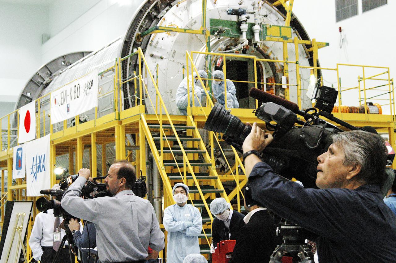 The Japanese Experiment Module or JEM (background) and other hardware undergoing processing for transport to the International Space Station are made available to photographers in the Space Station Processing Facility (SSPF). Members of the media were invited to commemorate the fifth anniversary of the launch of the first element of the International Space Station by touring the SSPF. Reporters had the opportunity to see Space Station hardware that is being processed for deployment once the Space Shuttles return to flight, as well as talk with NASA and Boeing mission managers about the various hardware elements currently being processed for flight.