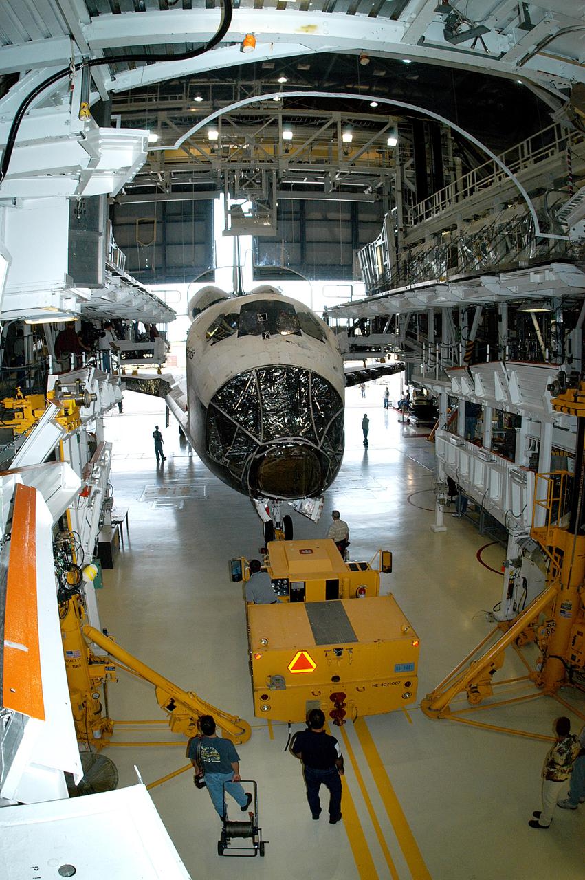 KENNEDY SPACE CENTER, FLA. - Workers prepare to tow the Space Shuttle orbiter Atlantis from the Orbiter Processing Facility (OPF) to the Vehicle Assembly Building (VAB). The move will allow work to be performed in the OPF that can only be accomplished while the bay is empty. Work scheduled in the processing facility includes annual validation of the bay's cranes, work platforms, lifting mechanisms, and jack stands. Atlantis will remain in the VAB for about 10 days, then return to the OPF as work resumes to prepare it for launch in September 2004 on the first return-to-flight mission, STS-114.