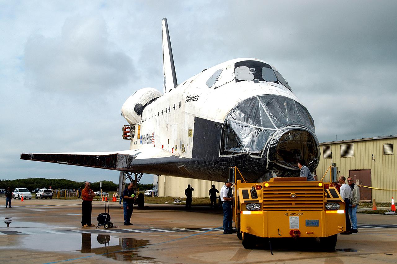 KENNEDY SPACE CENTER, FLA. - The Space Shuttle orbiter Atlantis is towed from the Orbiter Processing Facility (OPF) to the Vehicle Assembly Building (VAB). The move will allow work to be performed in the OPF that can only be accomplished while the bay is empty. Work scheduled in the processing facility includes annual validation of the bay's cranes, work platforms, lifting mechanisms, and jack stands. Atlantis will remain in the VAB for about 10 days, then return to the OPF as work resumes to prepare it for launch in September 2004 on the first return-to-flight mission, STS-114.