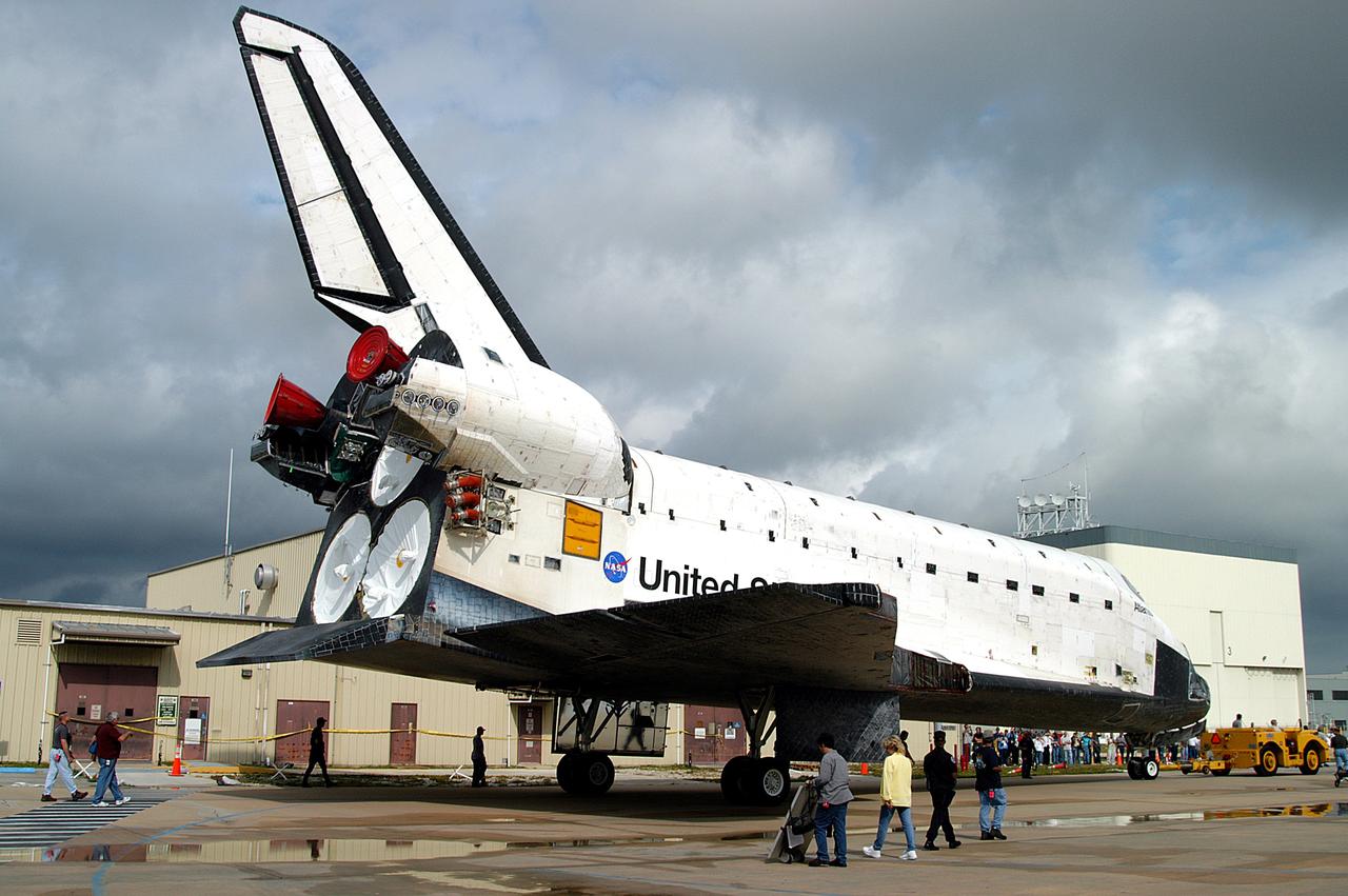 KENNEDY SPACE CENTER, FLA. - Workers monitor the Space Shuttle orbiter Atlantis as it is towed from the Orbiter Processing Facility (OPF) to the Vehicle Assembly Building (VAB). The move will allow work to be performed in the OPF that can only be accomplished while the bay is empty. Work scheduled in the processing facility includes annual validation of the bay's cranes, work platforms, lifting mechanisms, and jack stands. Atlantis will remain in the VAB for about 10 days, then return to the OPF as work resumes to prepare it for launch in September 2004 on the first return-to-flight mission, STS-114.